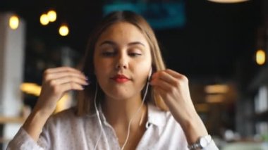 Genç güzel işkadını kulaklık Café müzik dinleme