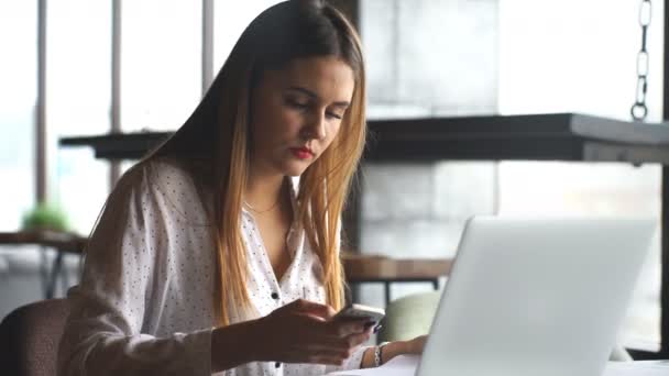 Mulher vestindo camisa branca pensando no café com computador portátil na mesa — Vídeo de Stock