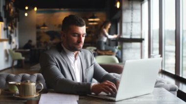 Dizüstü restoranda çalışan yakışıklı genç işadamı.