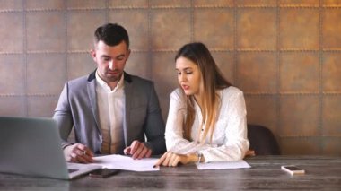 Genç iş adamı ve kafede oturan ve sözleşme tartışıyor kadın