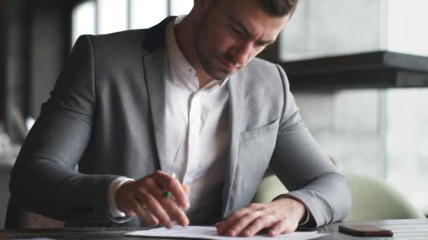 Empresário escrevendo em um papel em seu escritório — Vídeo de Stock