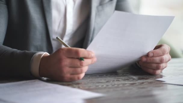 Стильний молодий бізнесмен в сірому костюмі підписує контракт — стокове відео