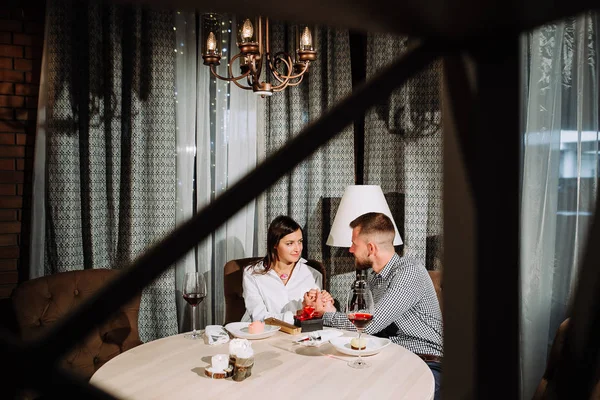 Giovane coppia felice appuntamento romantico bere un bicchiere di vino rosso al ristorante, celebrando il giorno di San Valentino — Foto Stock
