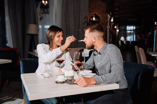 Pareja joven alimentándose mutuamente en el restaurante — Foto de Stock