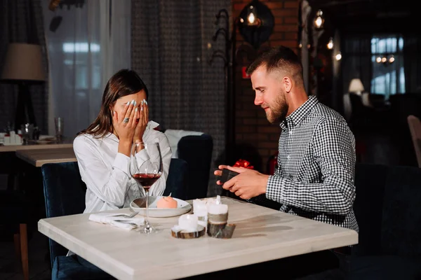 Porträtt av glad och förvånad ung kvinna som fick närvarande från pojkvän medan du sitter i café — Stockfoto
