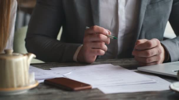 Hombre de negocios firmar contrato durante la reunión con un colega de negocios en la cafetería — Vídeo de stock