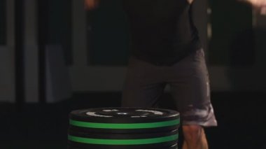 Atletik erkek spor salonunda atlama. CrossFit eğitim egzersiz. Erkek çıplak gövde egzersizleri ile koyu arka plan üzerine atlamak.