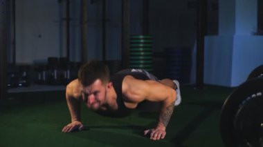 Sakallı güzel adam siyah arka plan üzerine spor salonunda bir pushup yapmak hazırlar