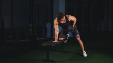 Yapan kaslı vücut geliştirmeci adam ayakta select ile halter halter salonunda uygular. Eğitim spor genç fitness adam