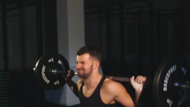Professionell idrottsman gör knäböj med en bar i gymmet — Stockvideo