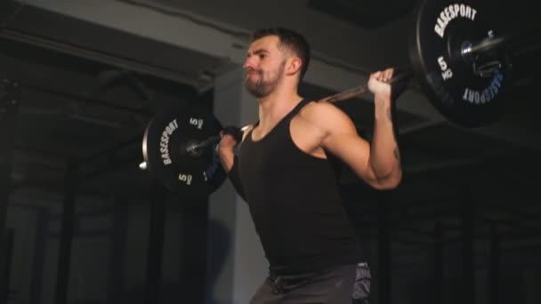 Atleta profesional hace sentadillas con un bar en el gimnasio — Vídeo de stock