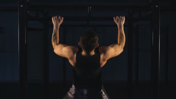 Musculoso poder fisiculturista cara fazendo pullups no ginásio. Homem de fitness bombeando músculos lats . — Vídeo de Stock