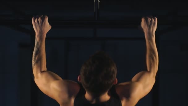Parte de trás muscular de treinamento de fisiculturista jovem em fundo escuro — Vídeo de Stock