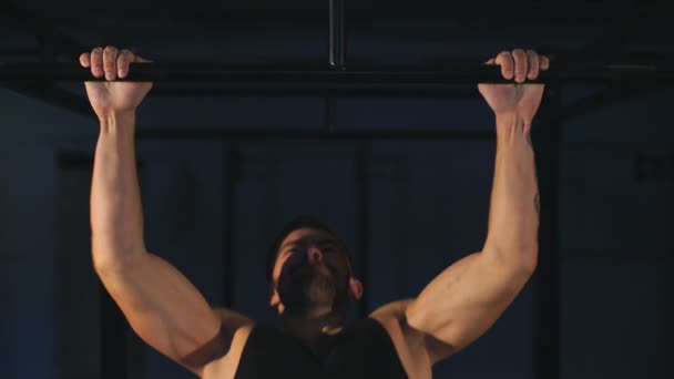 Gespierde achterkant van jonge bodybuilder opleiding in donkere achtergrond — Stockvideo