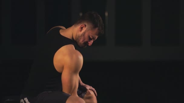 Jonge kracht atletische man doen oefening op biceps met zware halters zittend op de Bank in sportschool. — Stockvideo