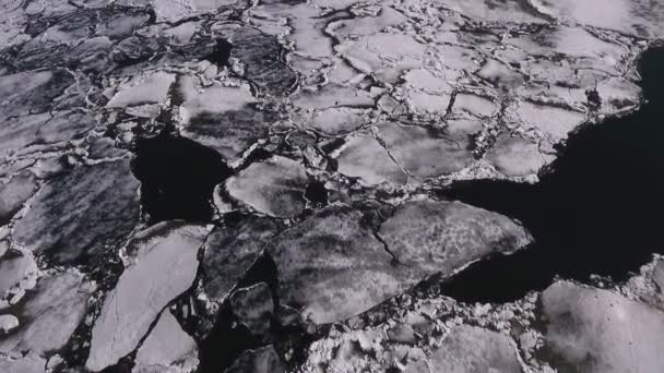 Aerial view over the surface of river and cracked ice — Stock Video