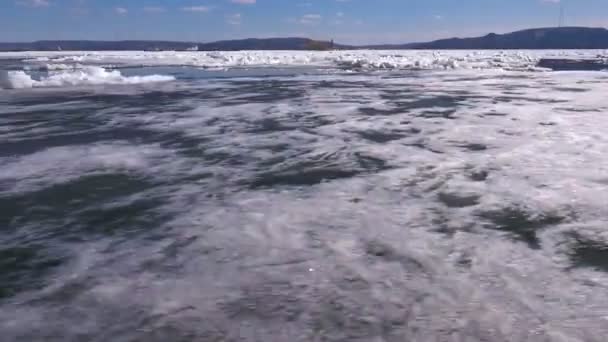 Вид с воздуха на поверхность реки и треснувший лед — стоковое видео