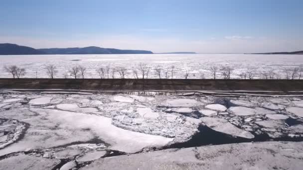 Летающий дрон над замерзшей рекой, водой и льдом на замерзшей реке — стоковое видео