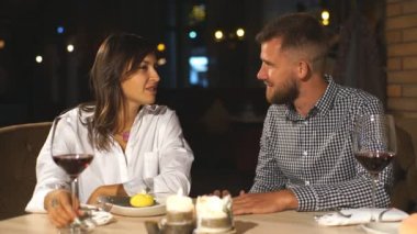 Genç adam kafede genç bir kıza hediye veriyor.