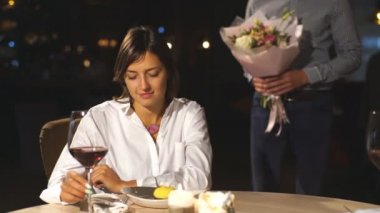 Kafede romantik çift güzel sürpriz. Genç adam onun sevgili çiçek sunuluyor. Mutluluk hissi.