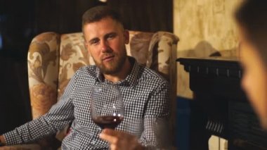 Şöminenin yanında şarap içmek ve bir kızla flört sakallı hippi adam