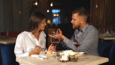 Genç bir çift bir restoranda akşam yemeği. Genç bir adam onun kız arkadaşı cheesecake ve kahkaha ile beslenir