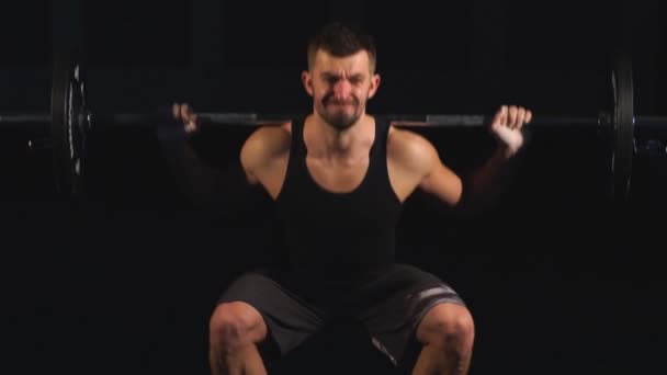 Professionell idrottsman gör knäböj med en bar i gymmet — Stockvideo