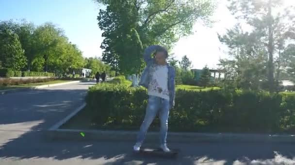 Giovane hipster a cavallo di un longboard lungo il lungomare — Video Stock