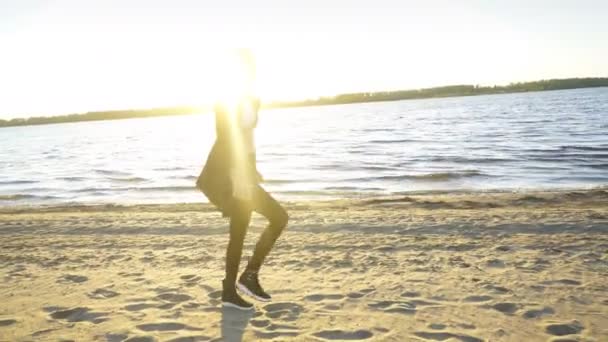 Hipster flicka dansa till rytmen och sjunga melodin på stranden — Stockvideo