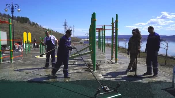 Il rivestimento della briciola di gomma viene posato all'aperto, su cemento, asfalto, legno, metallo e altre basi preparate. . — Video Stock