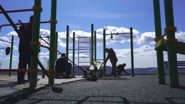 Um grupo de trabalhadores cobre o parque infantil revestido com migalhas de borracha — Vídeo de Stock