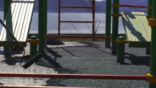 Eine Gruppe von Arbeitern bedeckt den Spielplatz mit Gummikrümeln — Stockvideo