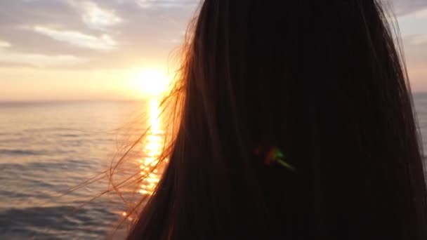 Mooie jonge vrouw op het strand kijken naar zonsondergang — Stockvideo