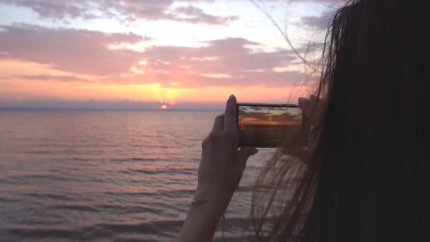 Junge Frau dreht Video von Sonnenuntergang — Stockvideo