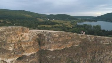Cliff, hava üzerinde mesafe içine sırasında romantik yürüyüş adam gösterir kız parmak üzerinde hava görünümünü çekim