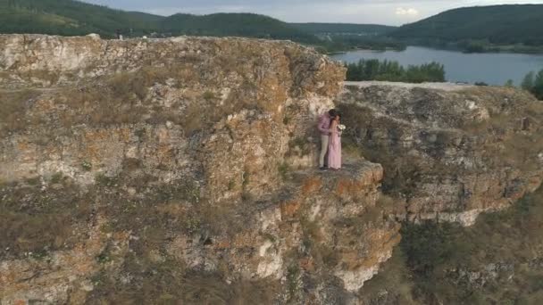 Εναέρια άποψη για νέους ζευγάρι στέκεται στα βράχια γύρω από την θάλασσα και τα βράχια — Αρχείο Βίντεο
