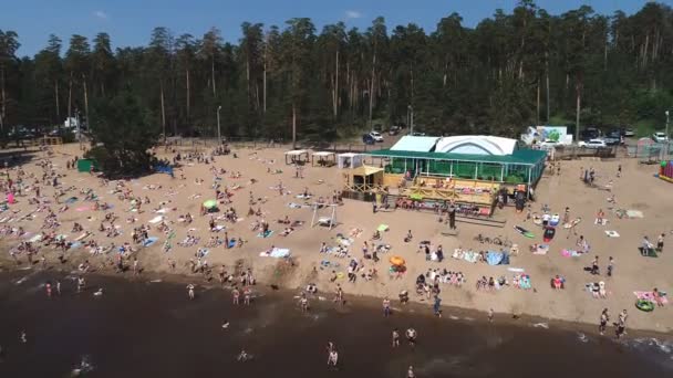 Togliatti, Oroszország, 2018. július 6.: azonosítatlan mindenki élvezi a hullámok egy zsúfolt tengerparton a légifelvételek — Stock videók