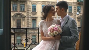 Gelin ve damat eski taş balkonda duran öp, Genç, güzel çift damat ve gelin balkonda durmak