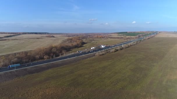 Letecký pohled na provoz na dvouproudové silnici přes krajinu a obdělávaná pole — Stock video