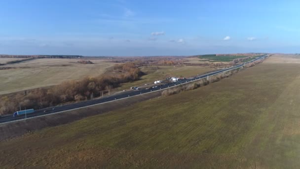 Flygfoto av trafiken på två körfält väg genom landsbygden och odlade fält — Stockvideo