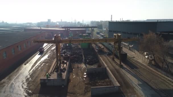 Промышленный экскаватор выгружает металлолом из вагонов — стоковое видео