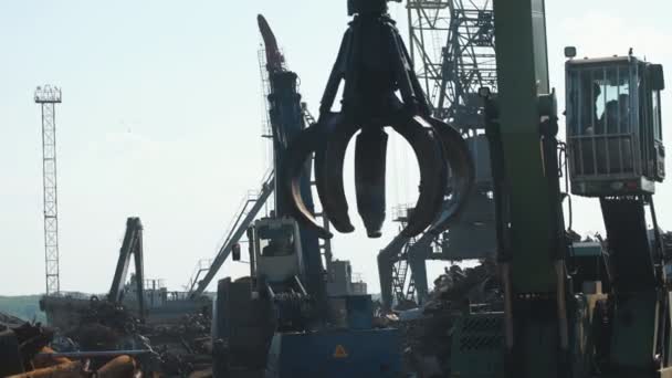 Máquina escavadora de sucata de metal com acessório de garra que move sucata de ferro e aço em torno do depósito de reciclagem — Vídeo de Stock