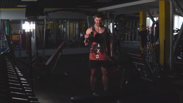 Gespierde jongeman trainen met halters. Guy treinen zijn biceps — Stockvideo