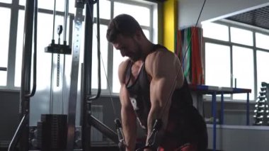 yakışıklı sportif adam spor salonunda crossover eğitim makinesinde egzersiz kadar iterek dışarı çalışır