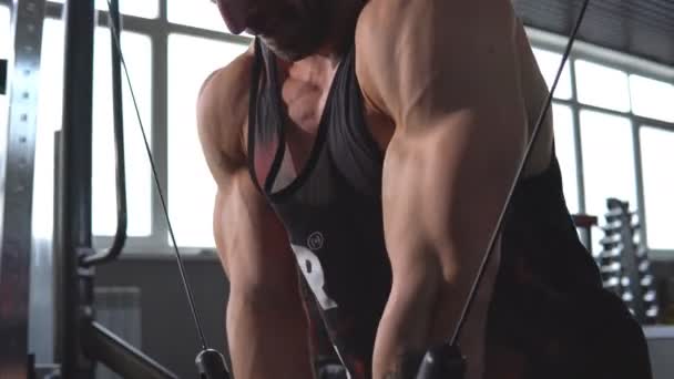 Brutal guapo culturista caucásico haciendo ejercicio en el gimnasio entrenamiento pecho bombeando músculos pectorales conpesas — Vídeos de Stock