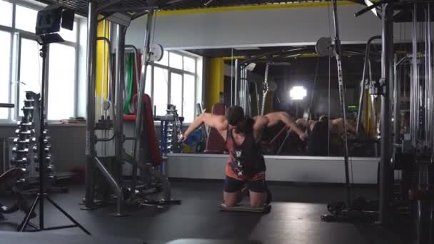 Парень культурист, выполнять упражнения с тренажером на грудных мышц, в тренажерном зале — стоковое видео