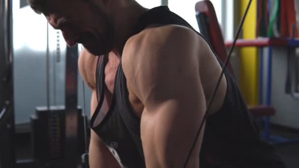 Schöner muskulöser Fitness-Bodybuilder macht Krafttraining für die Brust auf Maschine mit Kabel in der Turnhalle — Stockvideo