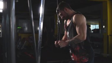 Makinenin yanında duran ve kollarını çalıştırırken kolu aşağı çeken motive adam.