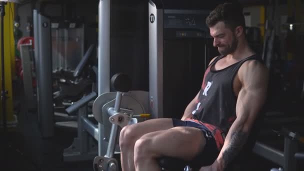 Красивый молодой спортивный мускулистый кавказский мужчина с образцовой внешностью тренируется в тренажерном зале — стоковое видео