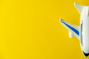 Yakın çekim beyaz uçak oyuncak sarı zemin üzerine. Seyahat kavramı